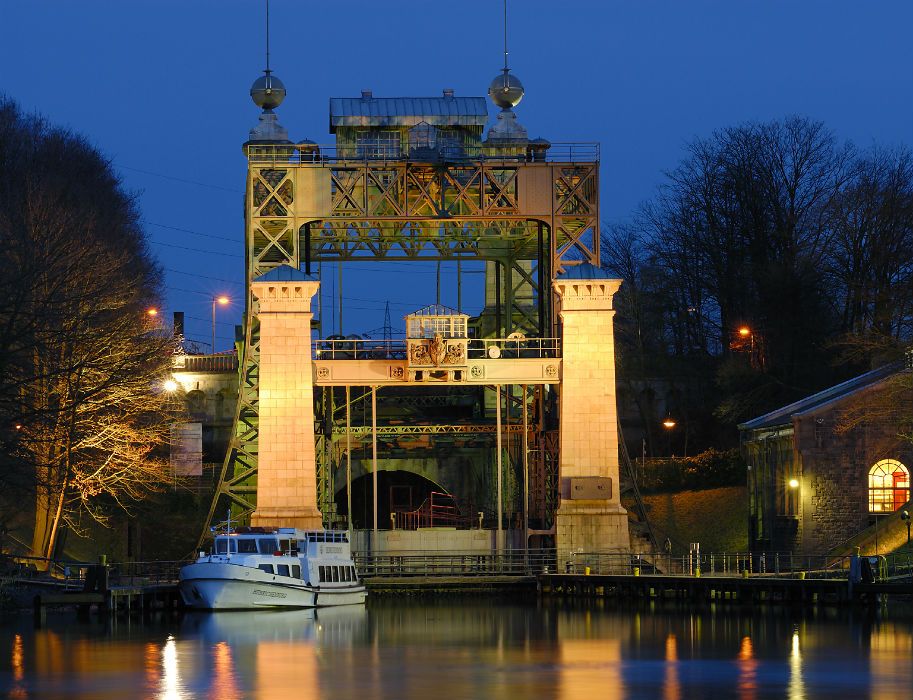 Am Abend ist das historische Industriegebäude des LWL-Schiffshebewerks Henrichenburg hell erleuchtet