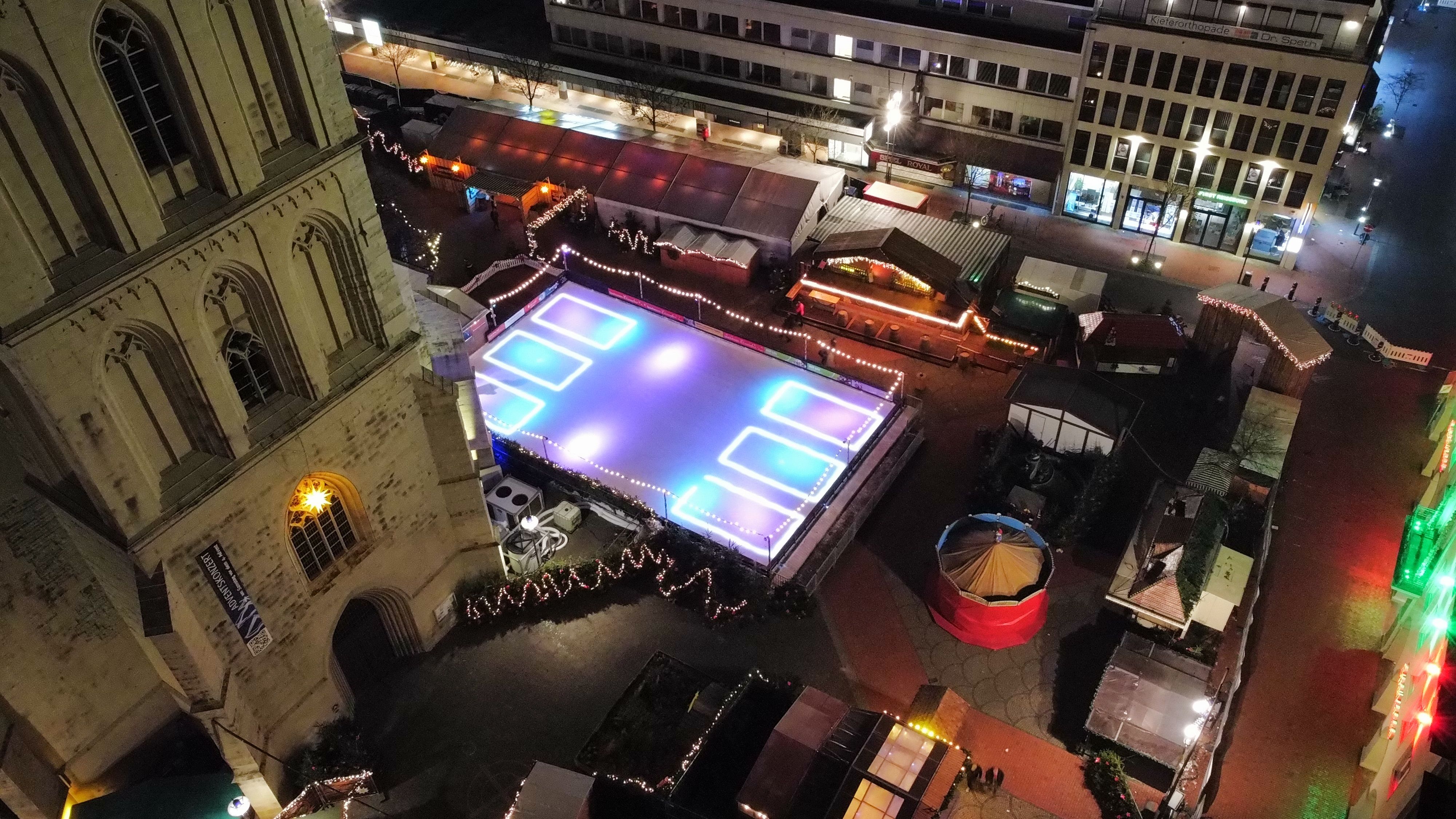 Blick auf Weihnachtsmarkt mit Eisfläche