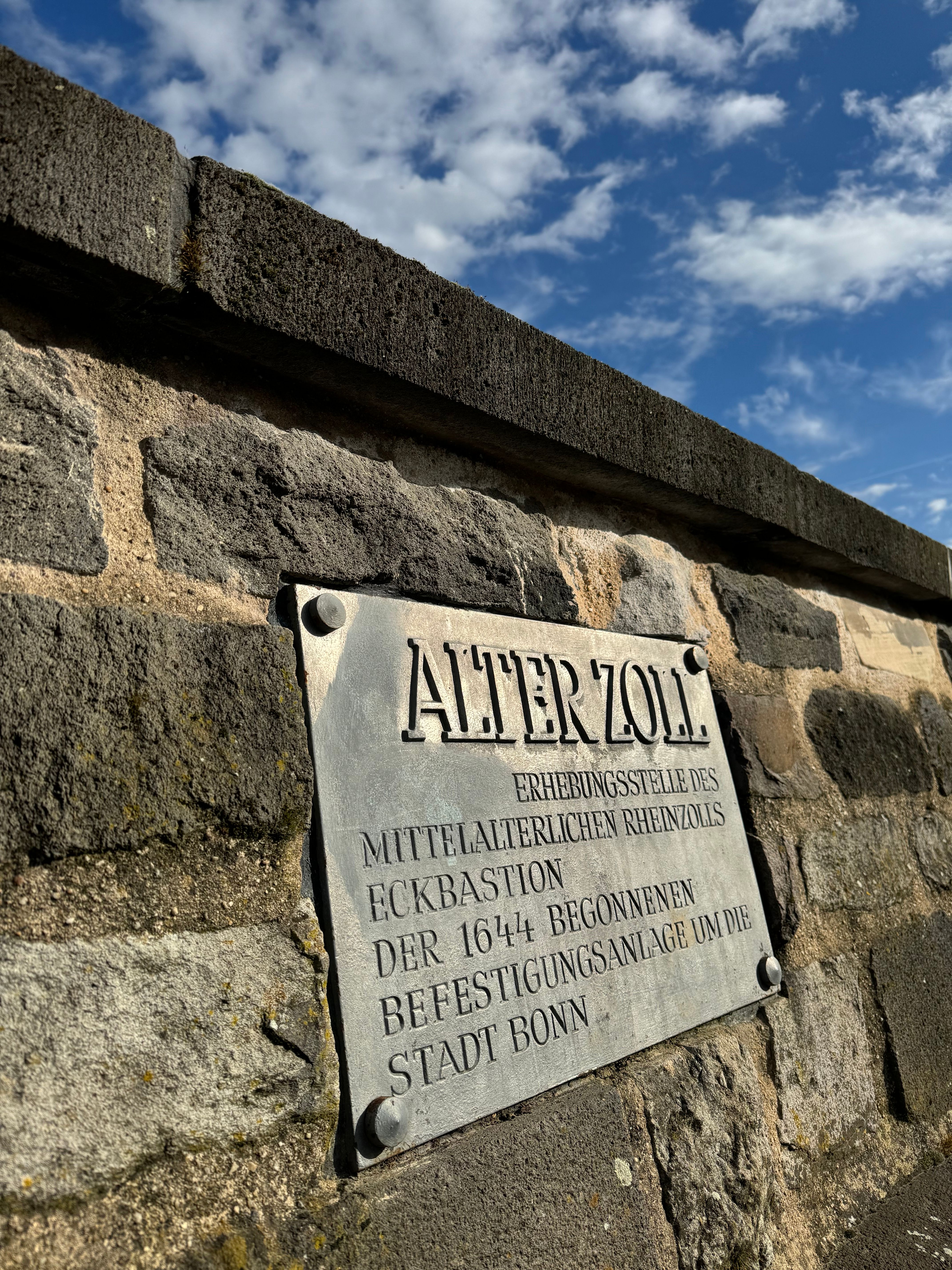 Ein Schild an einer Mauer mit der Aufschrift Alter Zoll in Bonn