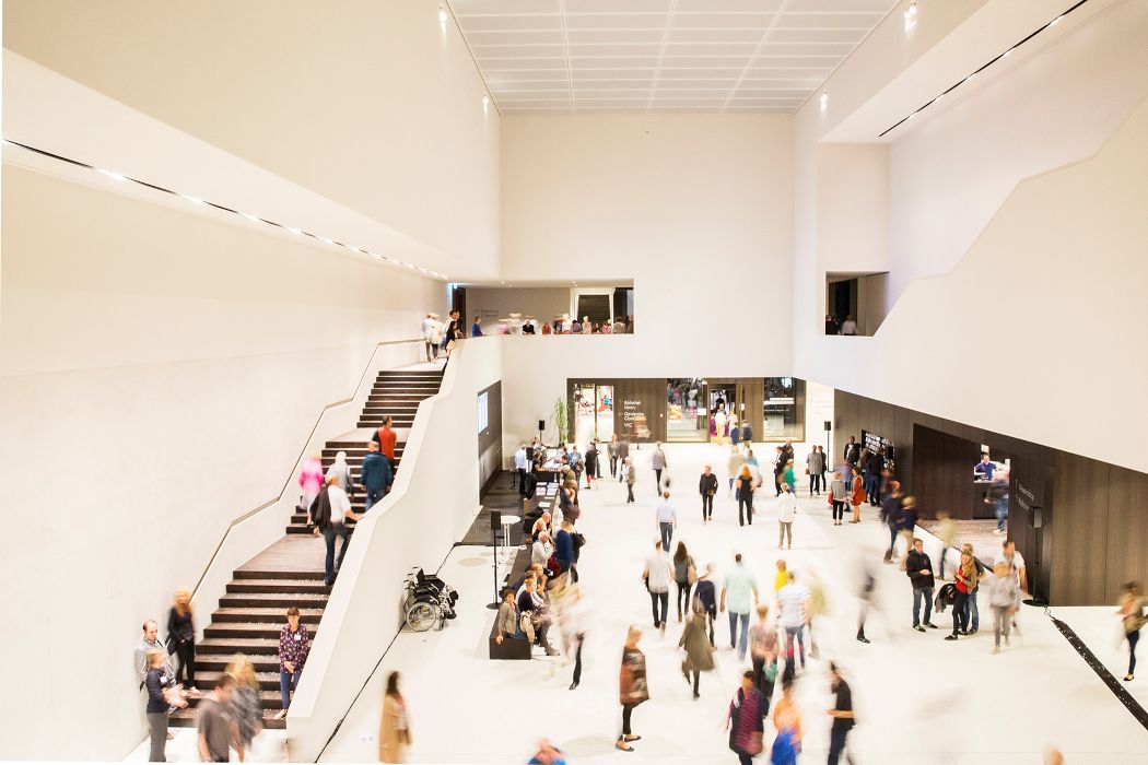 Gäste tummeln sich im lichtdurchfluteten Foyer des Museums