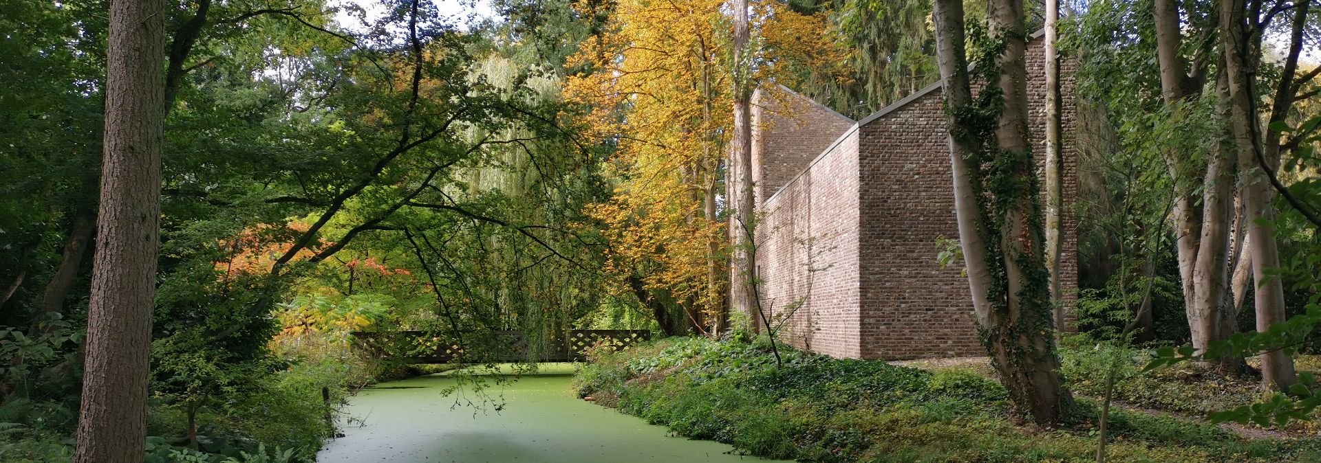 Eine von zehn begehbaren Skulpturen des Bildhauers Erwin Heerich an einem Wasserlauf in der Auenlandschaft