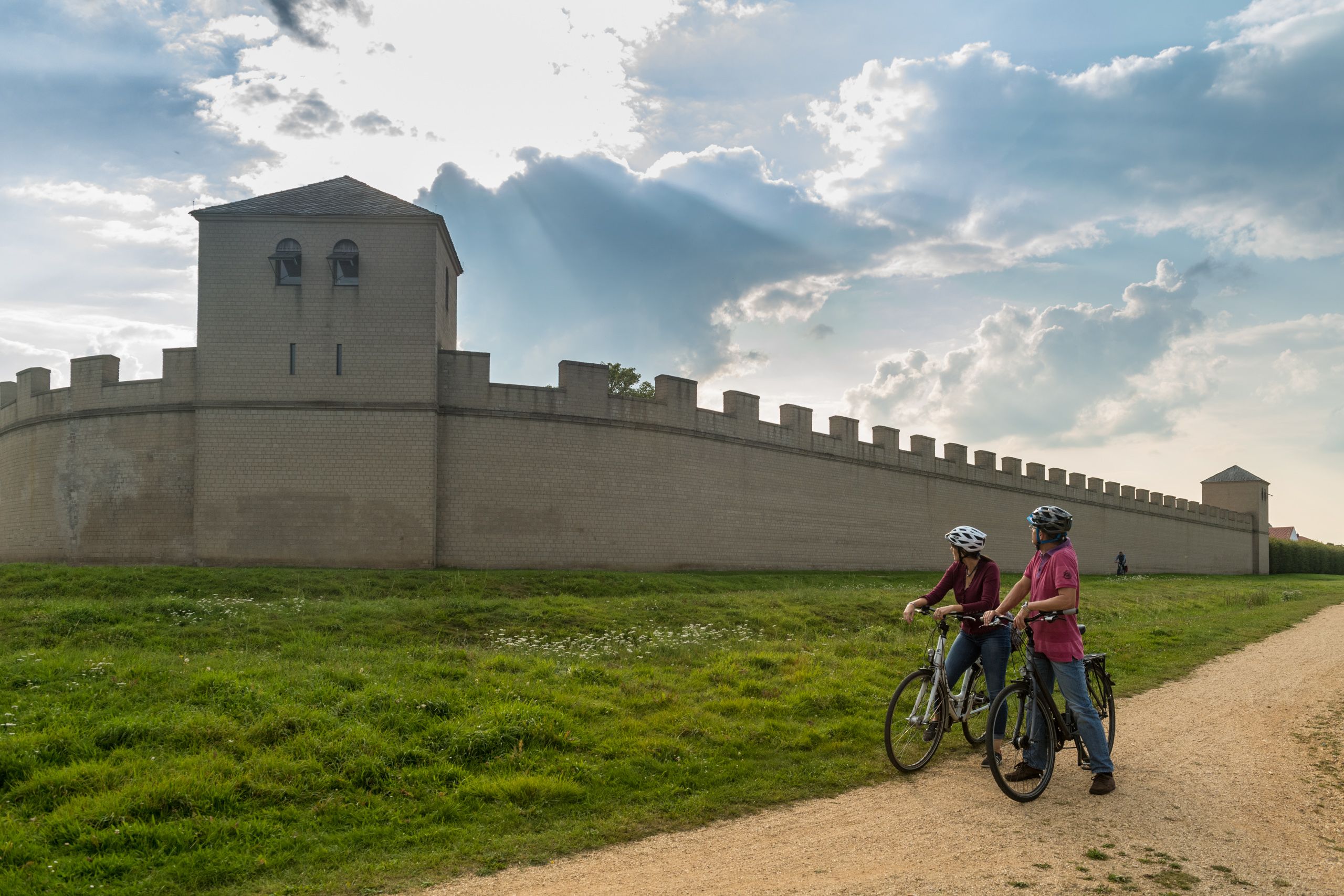 Radfahrende vor den Mauern des Archäologischen Parks Xanten