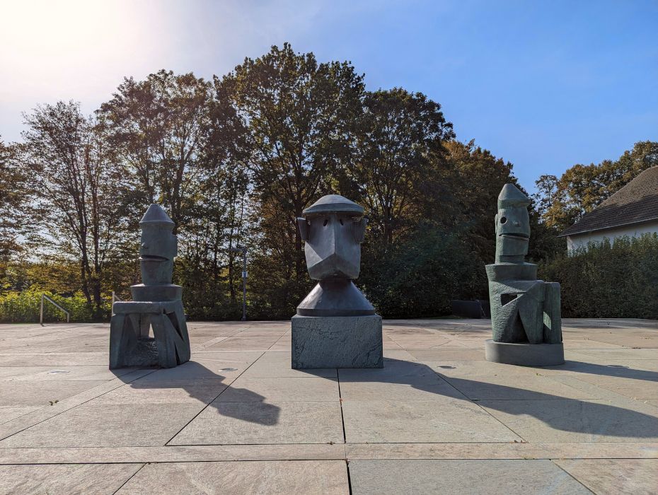 Die dreiteilige Bronze-Skulptur Lehrerkollegium einer Schule für Totschläger von Max Ernst steht vor dem Museumseingang