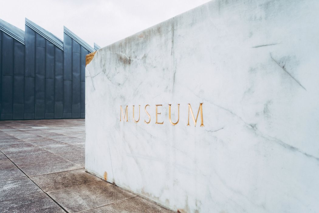 Ein goldener Schriftzug auf weißem Marmor kennzeichnet den Weg zum Eingang des Museums Abteiberg