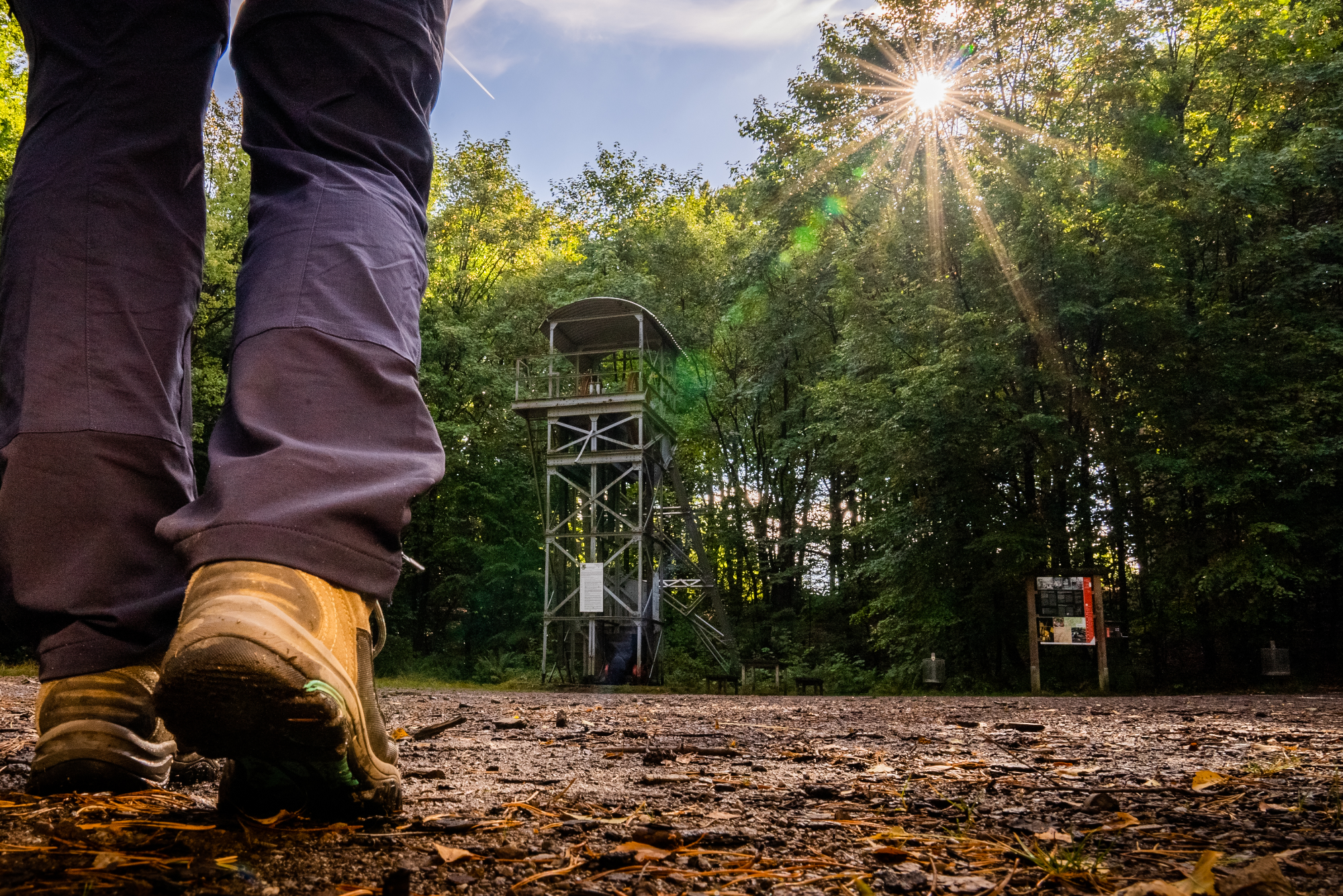 Fördergerüst im Wald, im Vordergrund Fuß eines Wandernden