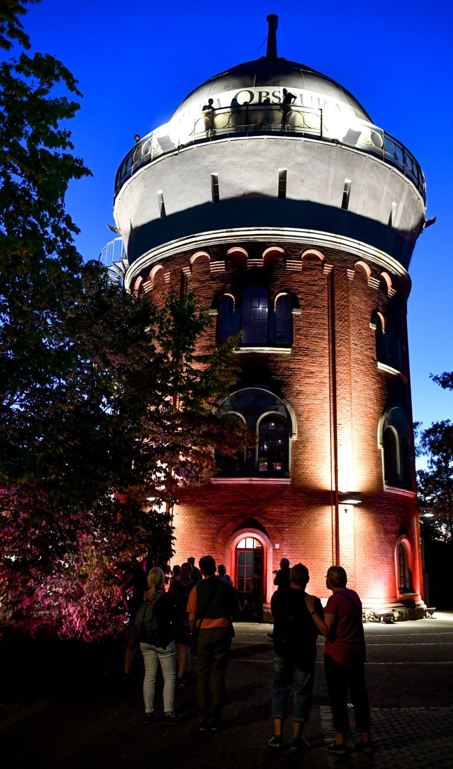 In den Abendstunden erhellen Lichter den 1904 erbauten Eisenbahnwasserturm mitten im MüGa-Park