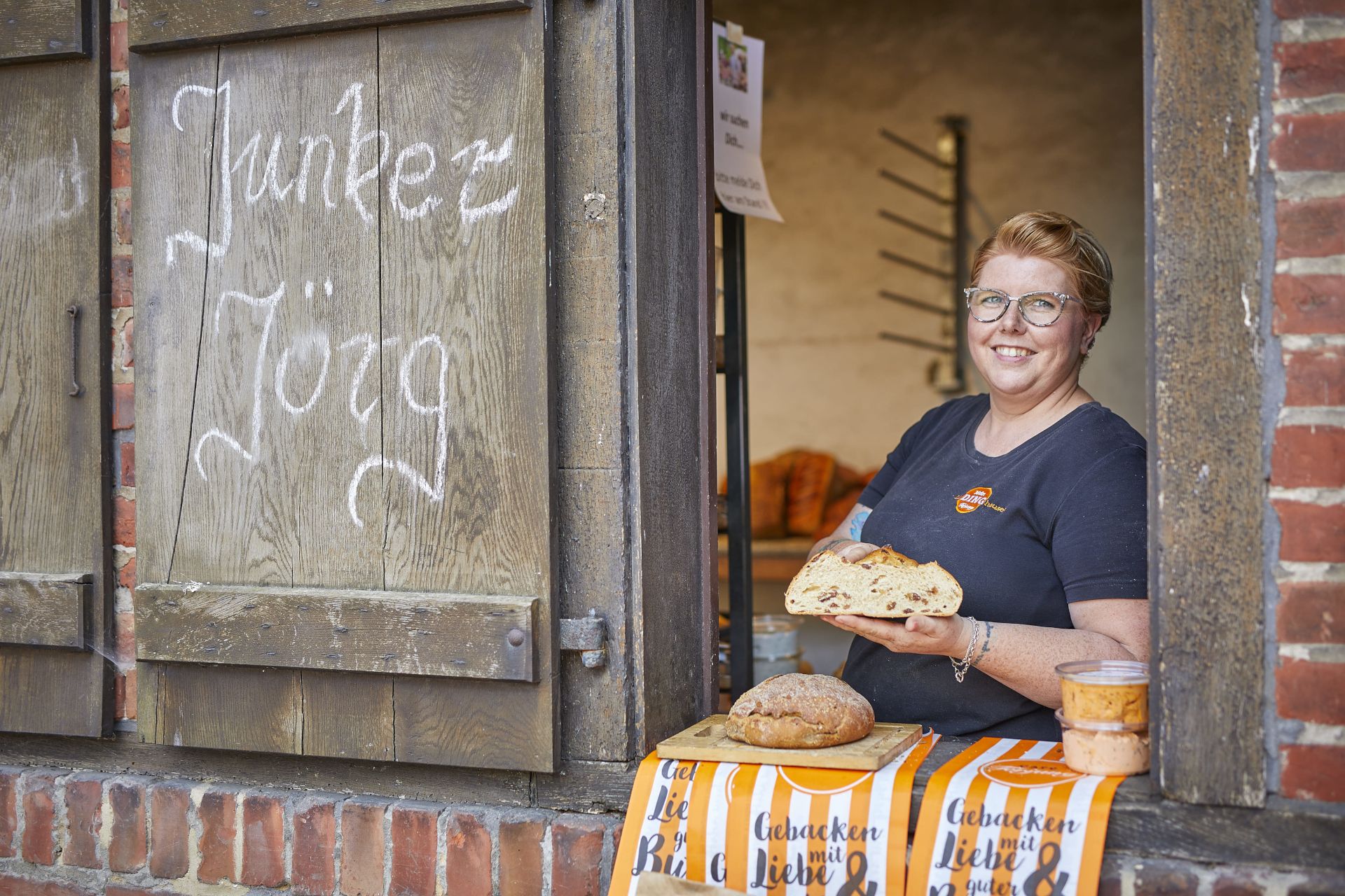 Junker Jörg verkauft auf Burg Vischering frisch gebackenes Brot am Bäckereifenster zum Schlösser- und Burgentag Münsterland