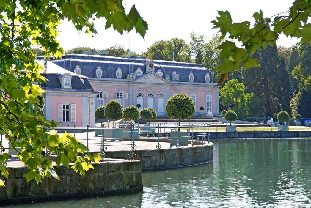 Der Rosaton des Schlosses Benrath fällt Besuchenden bereits vom Weg am Schlossweiher auf